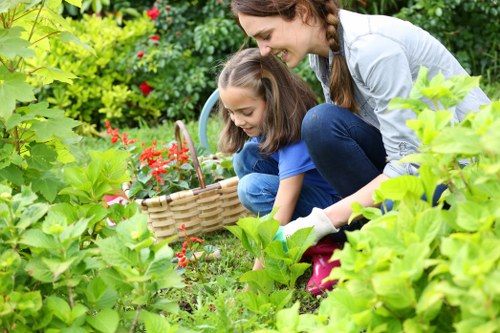 Front view of a Leyton garden with tidy beds and tools, representing Gardeners Leyton services